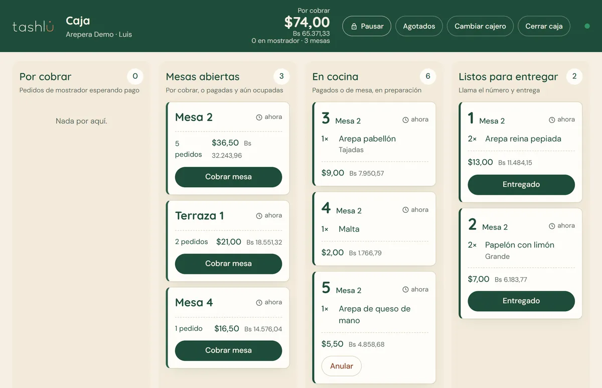 Caja de Tashlu en una tablet sobre su base, con el total por cobrar en dólares y bolívares, mesas abiertas y pedidos en cocina